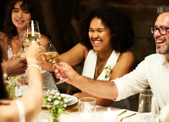 happy-young-african-american-bride-in-wedding-attire-toasting-with-friends